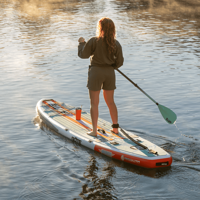 A girl paddling on the Breeze Aero 10'6" Full Trax Bloom Inflatable Paddle Board