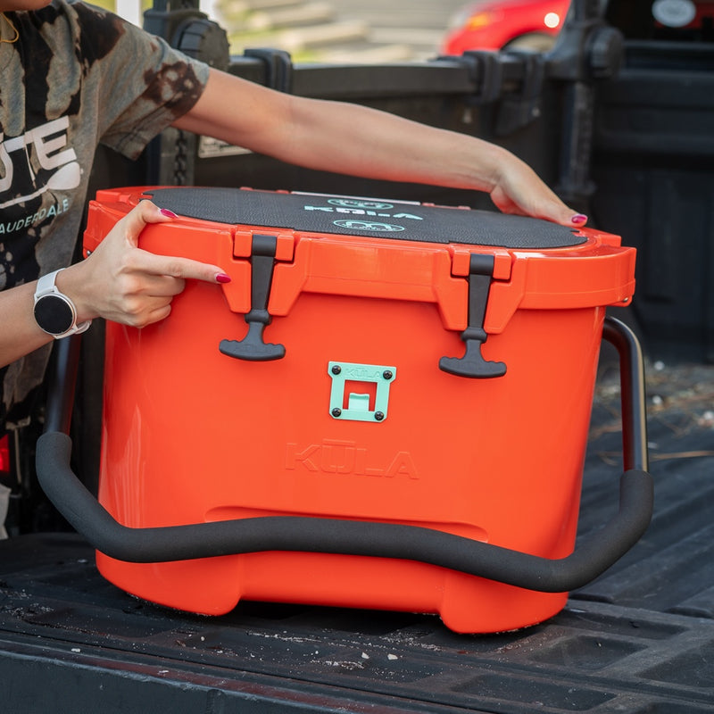 A KULA 10 MAGNEPOD™ Cooler Sunrise sitting on the back of a truck.