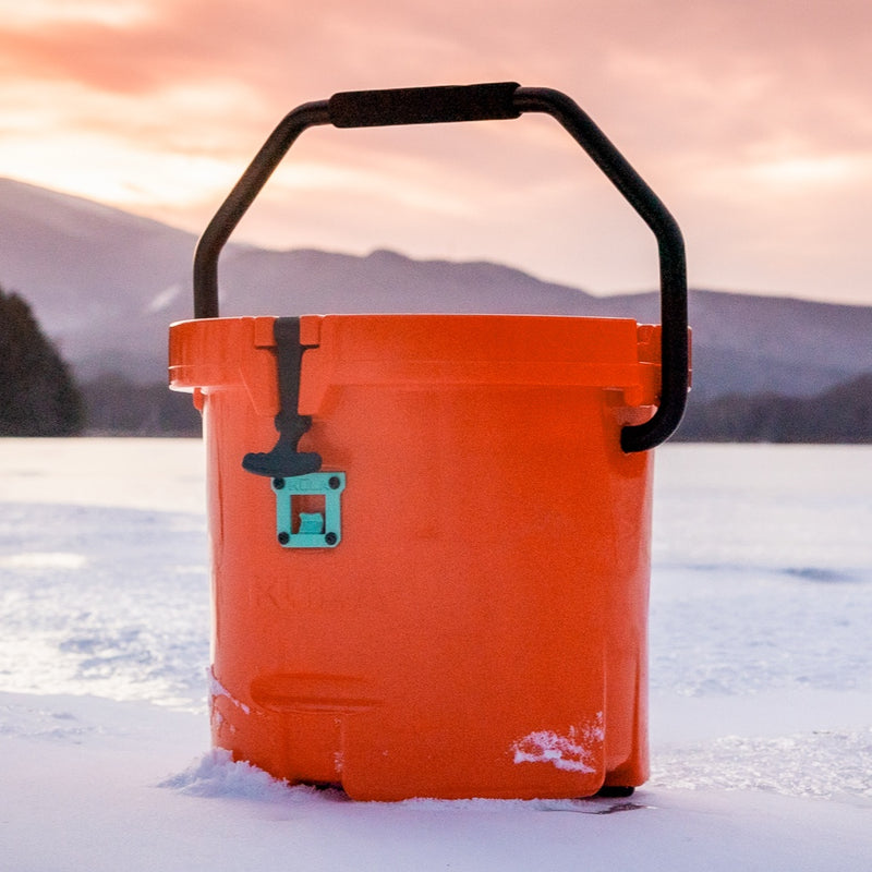 A KULA 5 MAGNEPOD™ Cooler Sunrise sitting on top of the snow.